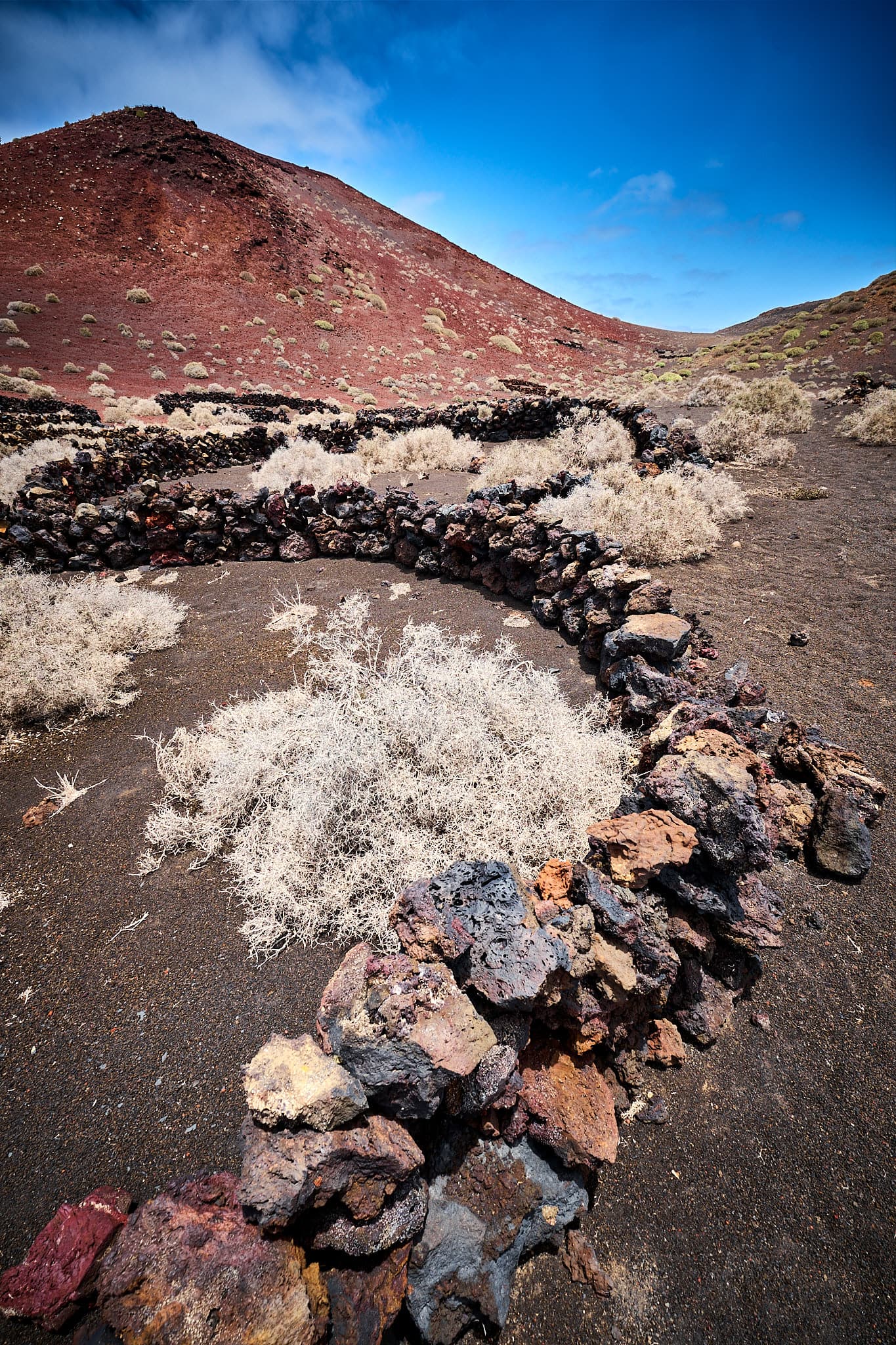 Kristian-Dill-Photographe-Paysage-Lanzarote-Vigne-Pierre-Arbuste-Montagne-Aride-Ocre-Bleu